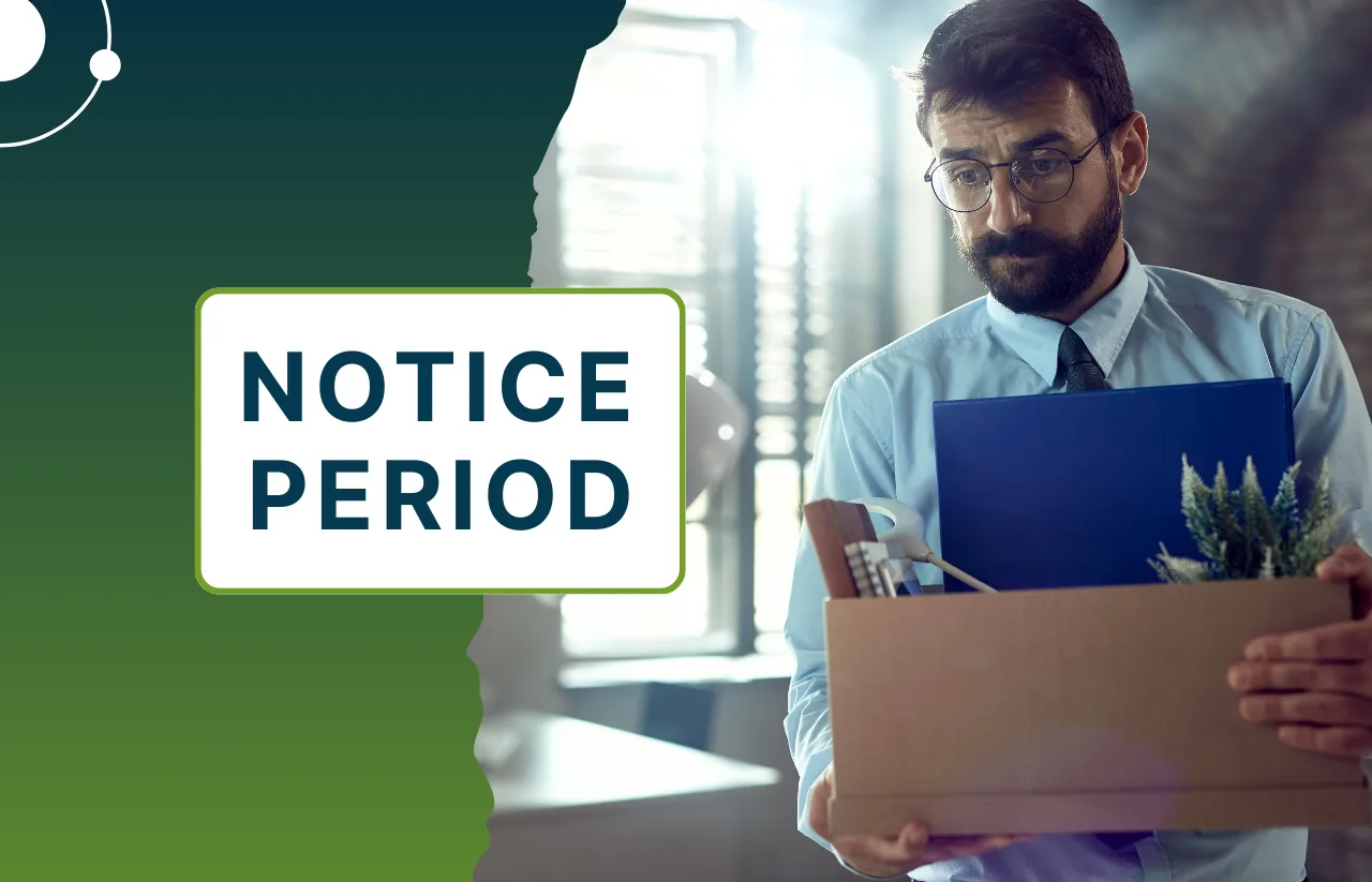 A man with glasses and a beard carrying a cardboard box in an office setting, illustrating the transition during a Notice Period with Remire HR services.