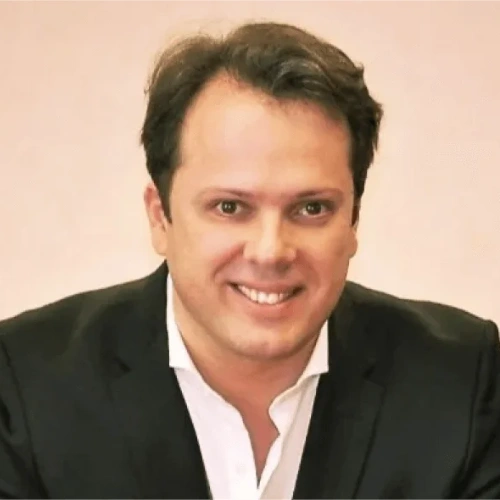 A professional portrait of Filipe Marques Group CRO at Remire, smiling and wearing a dark suit jacket with a white collared shirt.