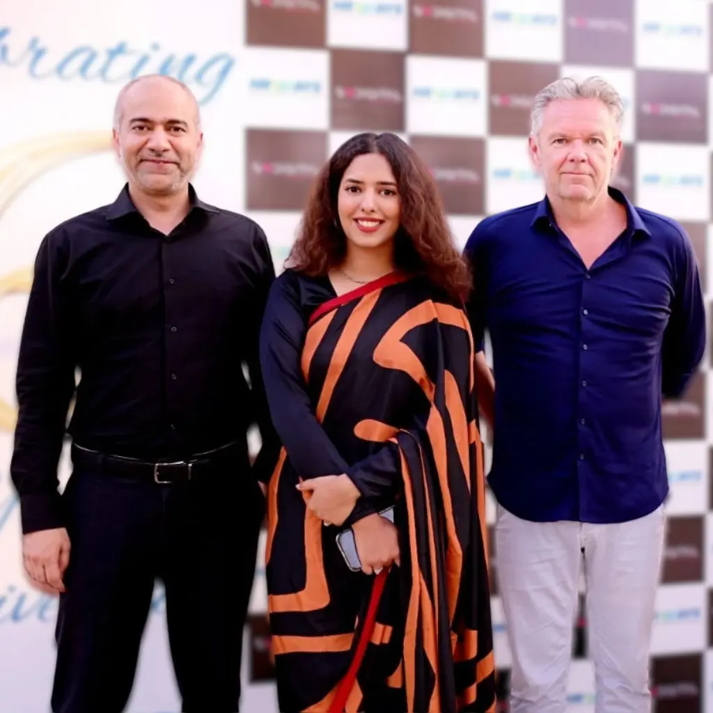 Three professional team members standing in front of a branded backdrop to announce that Remire got a mini physical office.