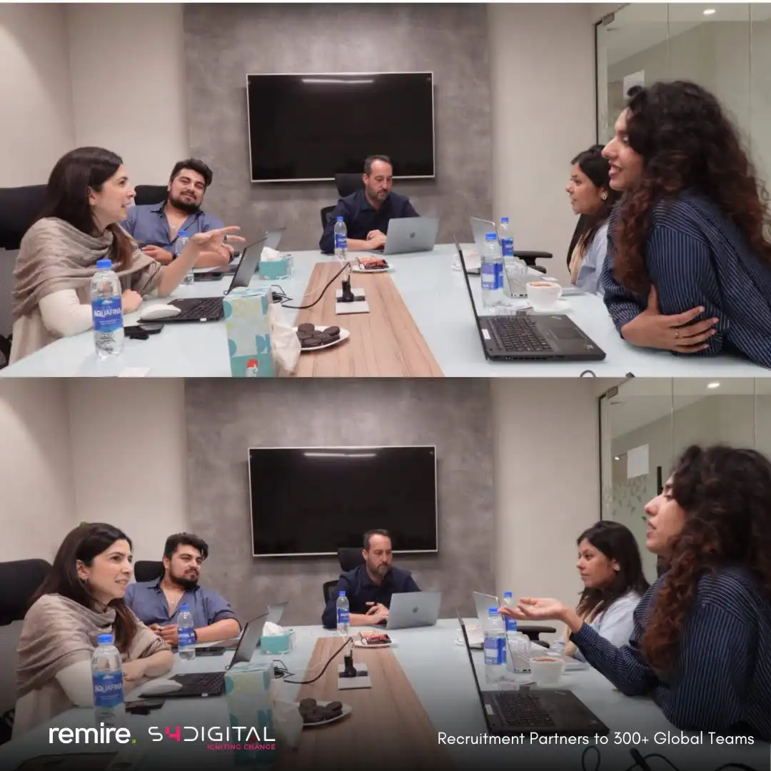 A group of five professionals in a modern conference room with laptops, representing the partnership where S4 expanded Remire as recruitment partners.